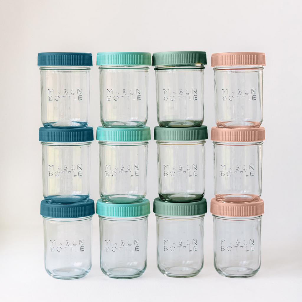 Set of clear glass jars with colorful lids on a white background